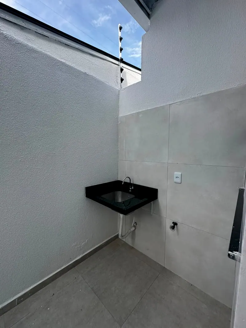 Área de serviço da casa, com tanque de granito e o céu aberto em cima