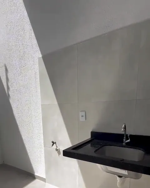 Área de serviço da casa, com pia de granito e o sol entrando