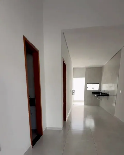 Corredor da casa, com forro de gesso e piso claro, em direção à cozinha