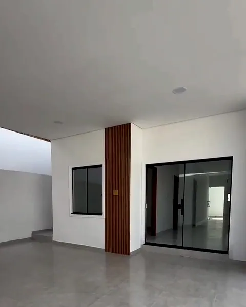 Frente coberta da casa, com painel ripado de madeira, janela e porta de vidro de correr