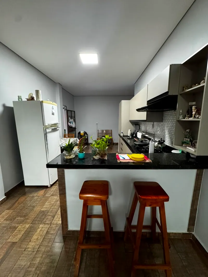 Cozinha com bancada de granito e banquetas