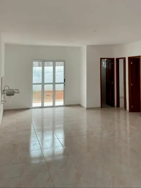 Sala de estar e jantar integradas à cozinha, com porta de vidro para o quintal