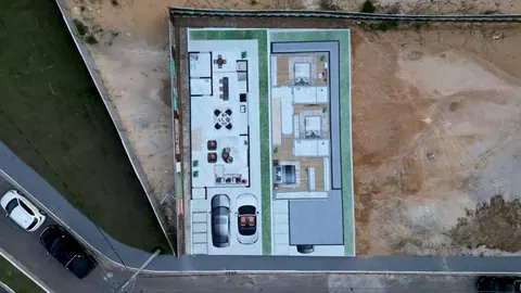 Imagem ilustrativa: um lote visto do alto, com a planta de uma casa desenhada por cima (perspectiva do empreendimento)